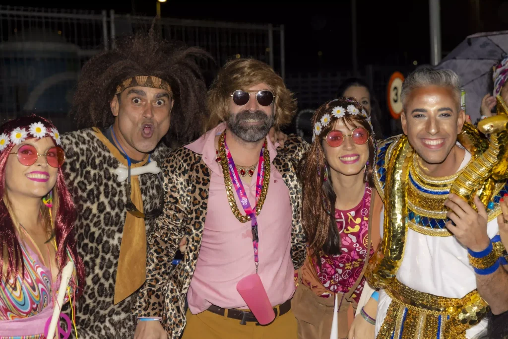 Fête nocturne animée du Carnaval de Tenerife à la Plaza de España avec des lumières de scène, des costumes colorés et des milliers de personnes.