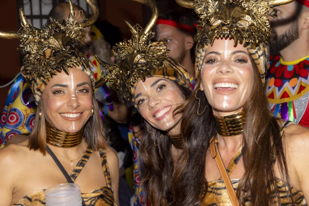 Fête nocturne animée du Carnaval de Tenerife à la Plaza de España avec des lumières de scène, des costumes colorés et des milliers de personnes.