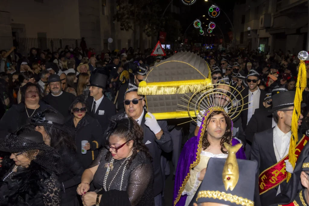 Cérémonie de l'Enterrement de la Sardine au Carnaval de Tenerife 2026 avec des pleureuses déguisées en veuves suivant un énorme char de sardine.