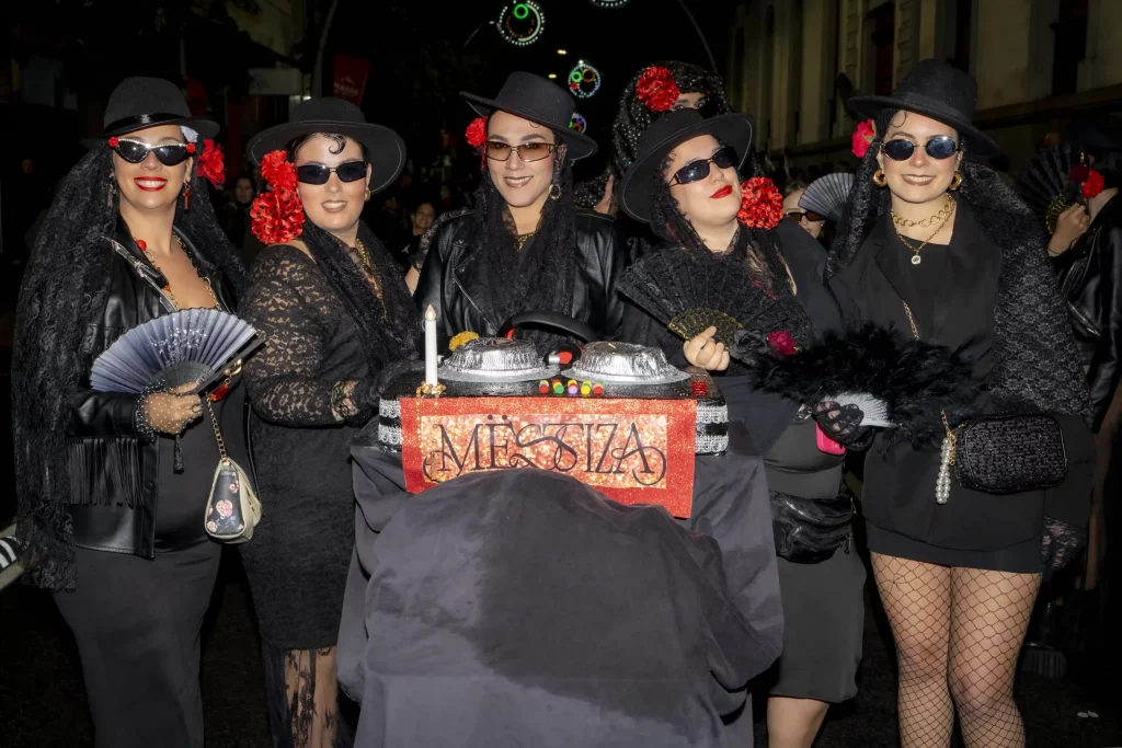 Cérémonie de l'Enterrement de la Sardine au Carnaval de Tenerife 2026 avec des pleureuses déguisées en veuves suivant un énorme char de sardine.