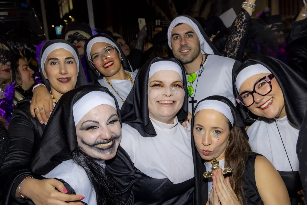 Cérémonie de l'Enterrement de la Sardine au Carnaval de Tenerife 2026 avec des pleureuses déguisées en veuves suivant un énorme char de sardine.