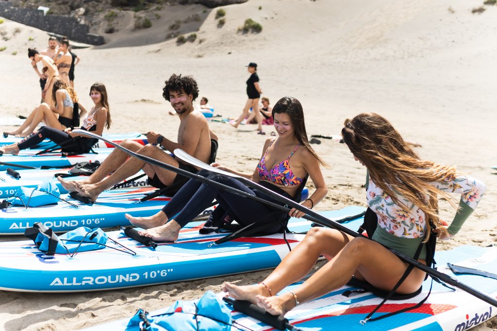 Instructor de paddleboard enseñando técnica SUP a principiantes en Costa Adeje Tenerife experiencias